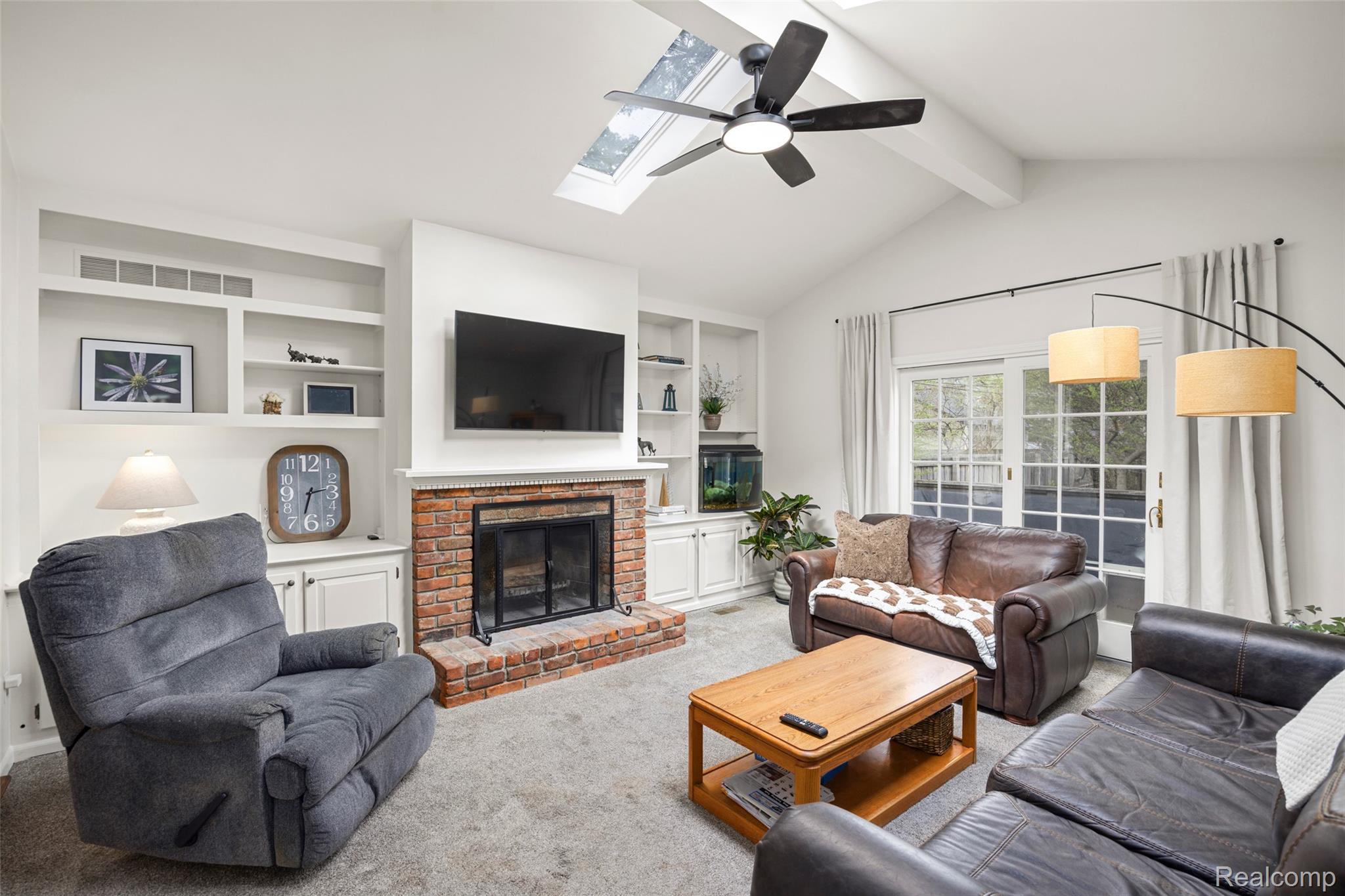 244 Kerby Road Grosse Pointe, MI 48236 - Photo 3 of 53 Family room addition with vaulted ceilings, natural fireplace, built-ins, skylights, and sliding door to back deck.