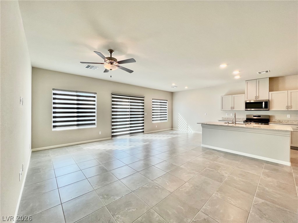7845 Morganite Avenue Las Vegas, NV 89113 - Photo 3 of 21 An open concept living area seamlessly blends into a contemporary kitchen, perfect for entertaining.