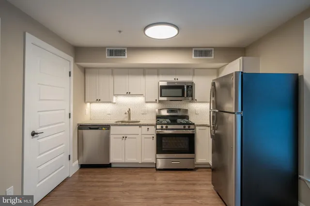 a kitchen with stainless steel appliances a refrigerator stove and sink