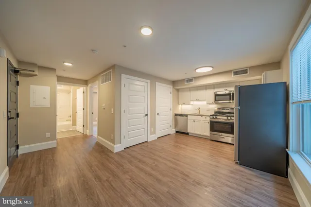 a kitchen with a refrigerator and white cabinets