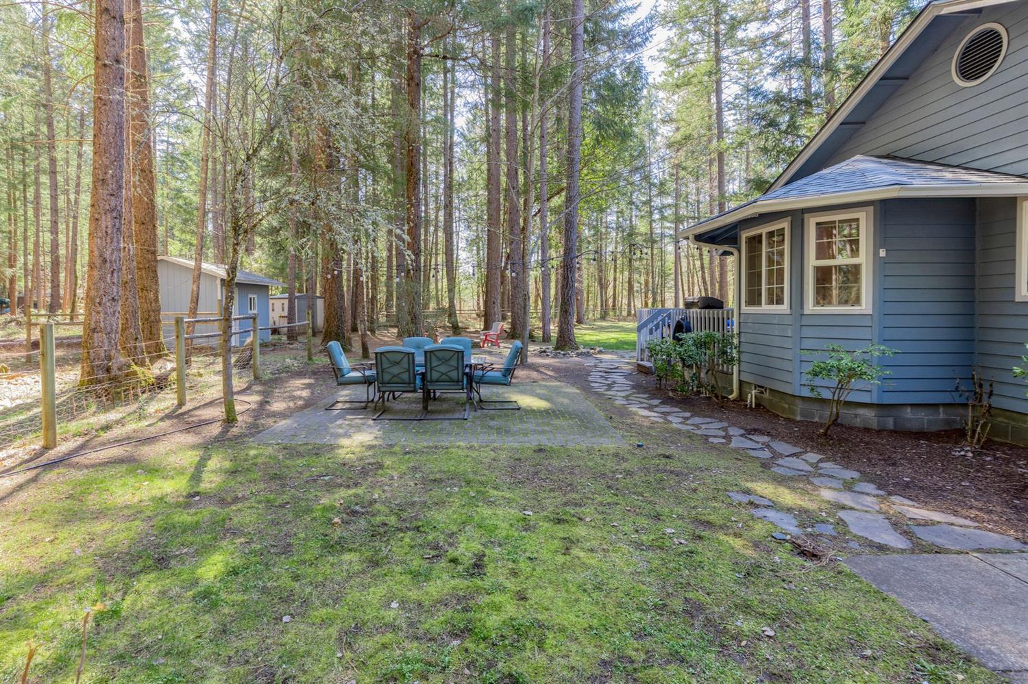 4623 Dick George Road Cave Junction, OR 97523 - Photo 21 of 26 a backyard of a house with table and chairs
