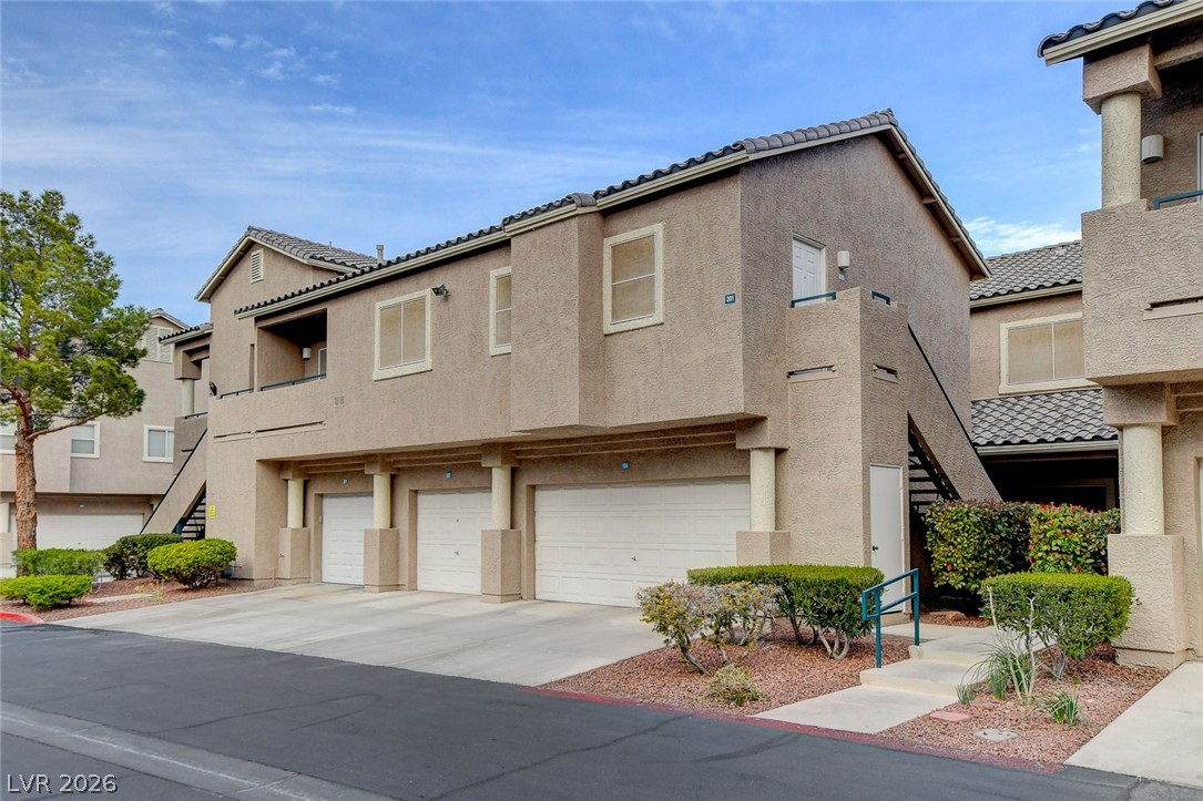 2052 Quarry Ridge Street, Unit 201 Las Vegas, NV 89117 - Photo 1 of 25 Attached multi-unit garages with direct outdoor access and landscaping complement this modern structure.