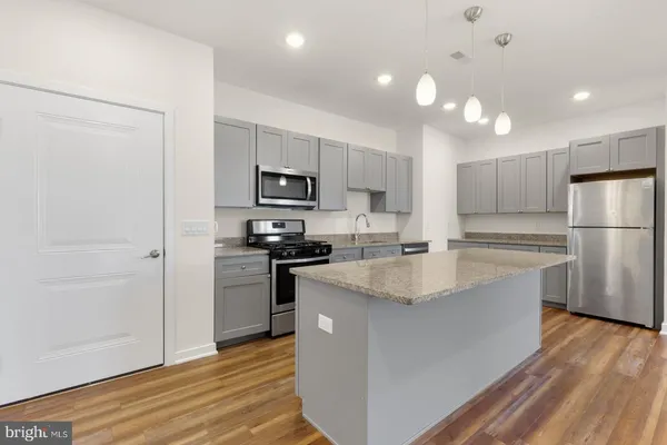 a kitchen with kitchen island a sink stainless steel appliances and cabinets