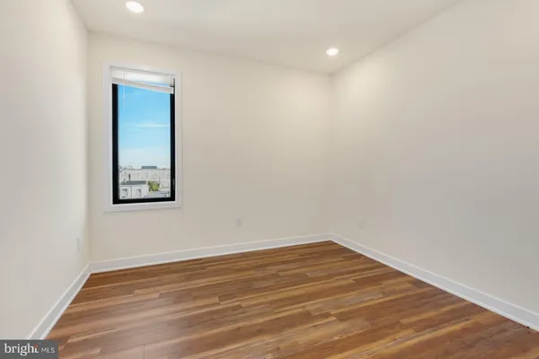 a view of a room with wooden floor and white walls