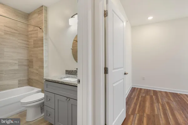 a bathroom with a granite countertop sink a toilet and shower
