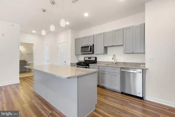 a kitchen with a sink cabinets and wooden floor