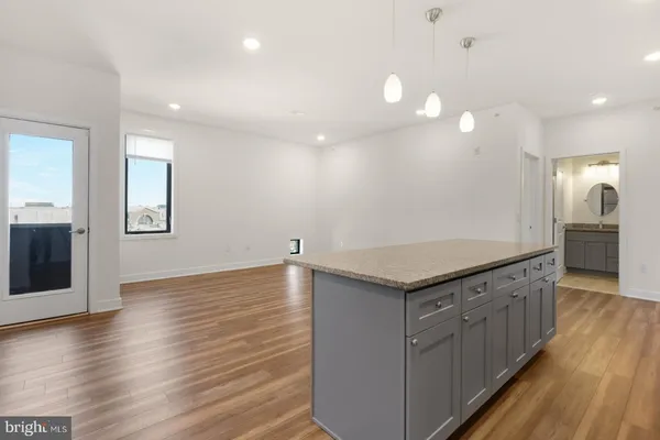a kitchen with a stove and wooden floor