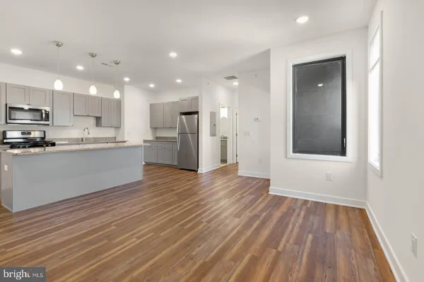a view of kitchen with wooden floor and electronic appliances