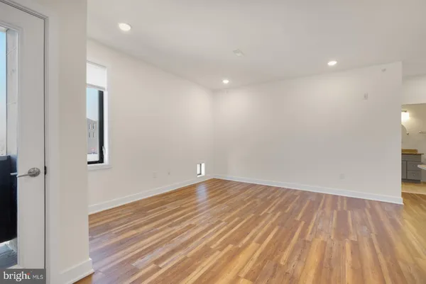a view of room with wooden floor and white walls