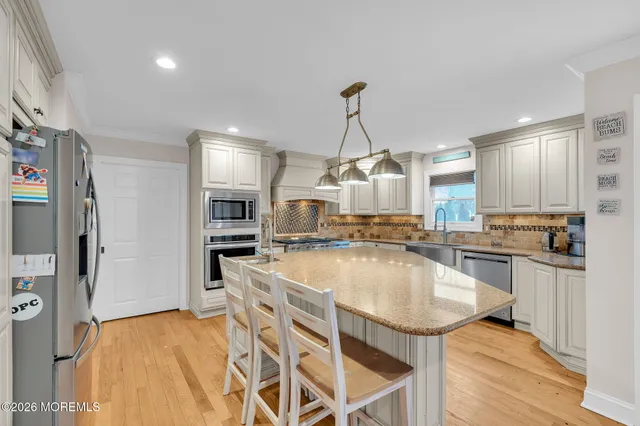 a kitchen with stainless steel appliances granite countertop a sink a stove top oven a counter space and cabinets