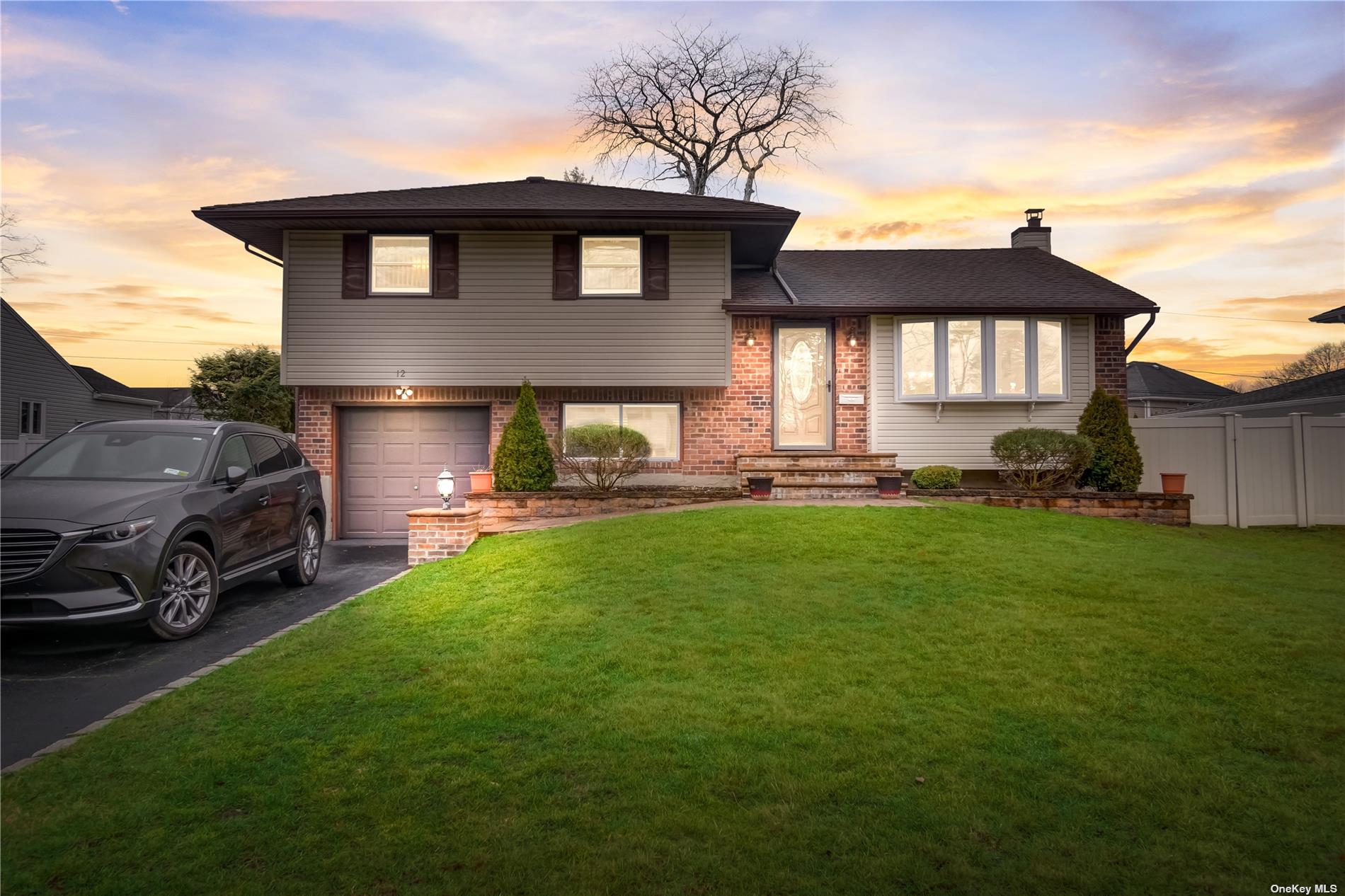 a front view of a house with a garden and yard