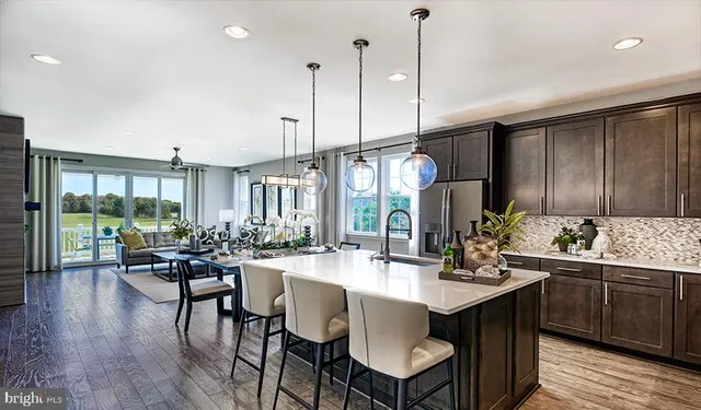 a view of a dining room and livingroom with furniture wooden floor a chandelier