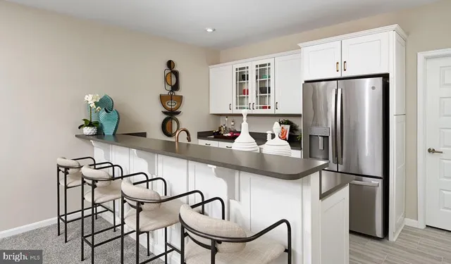 a kitchen with stainless steel appliances granite countertop a refrigerator and a stove top oven with wooden floor