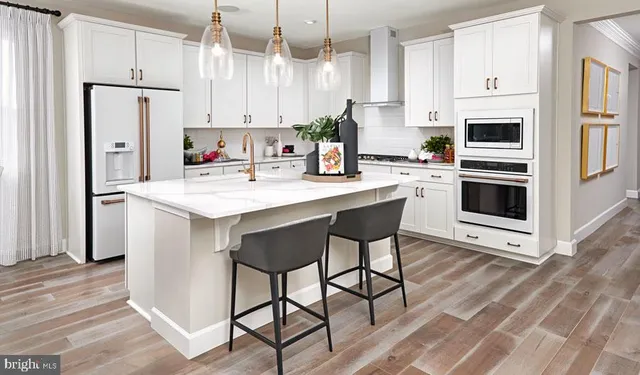 a kitchen with stainless steel appliances a stove a sink refrigerator and white cabinets with wooden floor