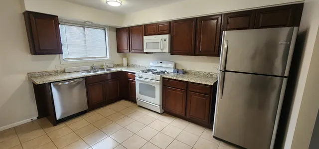 a kitchen with a refrigerator sink and cabinets