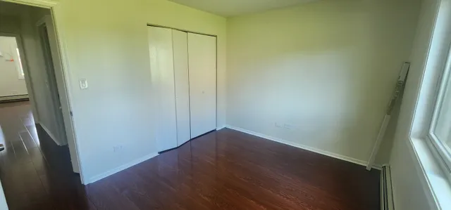 a view of a small space with wooden floor and a window