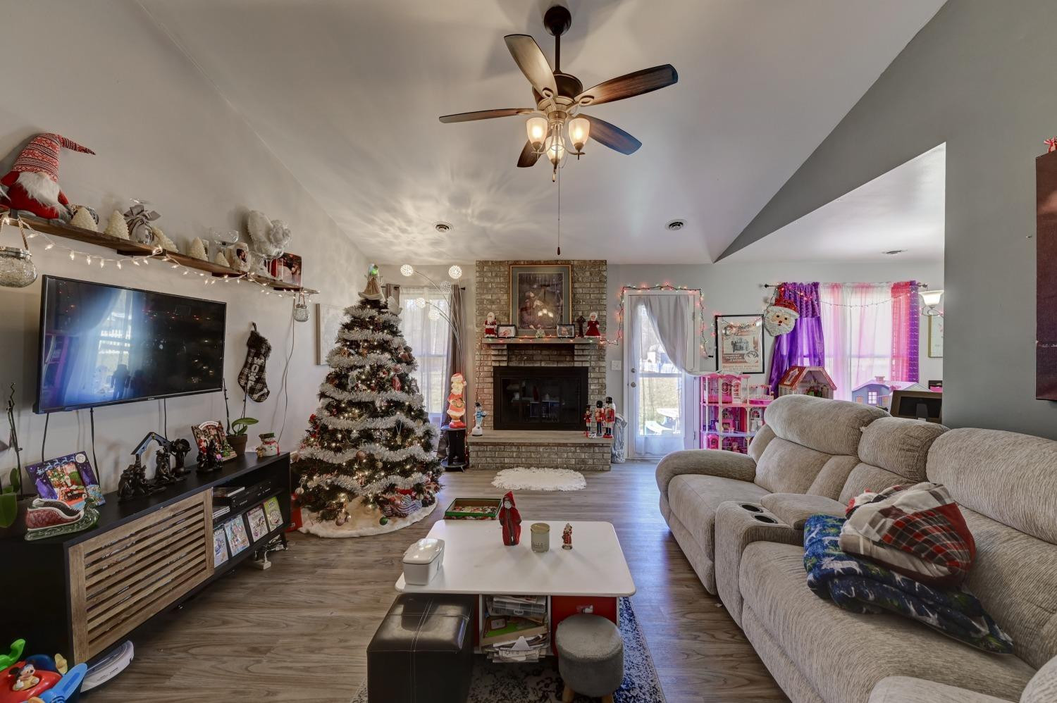 12134 North 332E Thayer, IN 46381 - Photo 2 of 16 a living room with furniture a flat screen tv and a fireplace