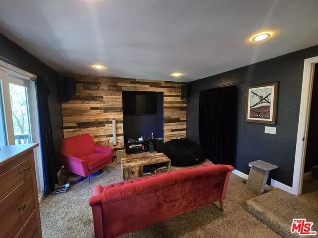 a outdoor living room with furniture and a flat screen tv