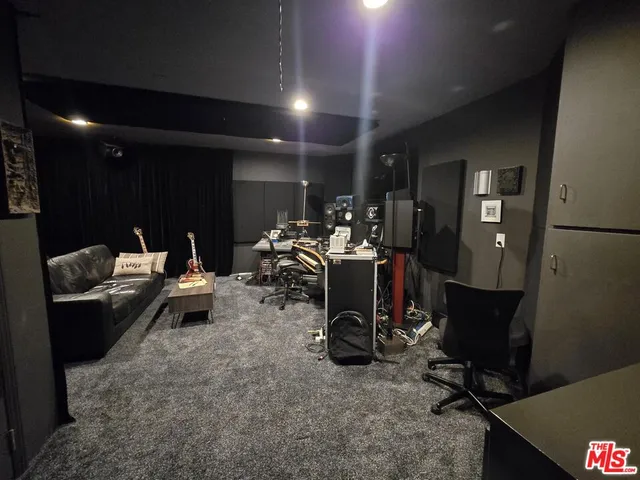 a living room with furniture a mirror and gym equipment