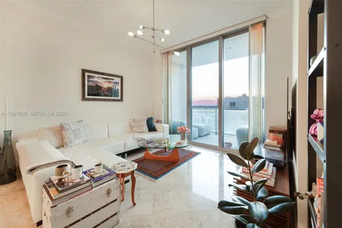 a living room with furniture a floor to ceiling window and a flat screen tv
