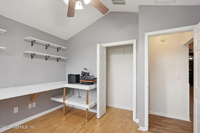 an empty room with windows and fan