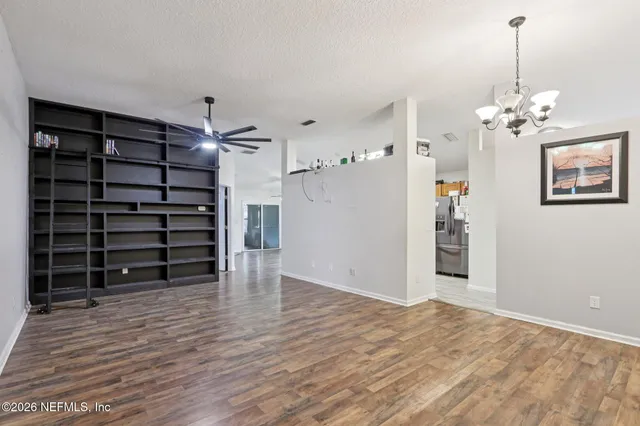 a view of empty room with wooden floor
