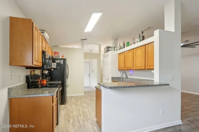 a kitchen with stainless steel appliances a refrigerator sink and microwave