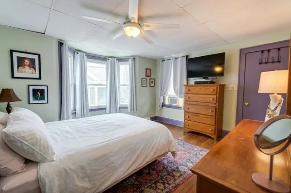 a bedroom with a bed and a flat screen tv