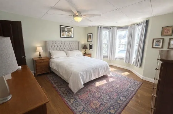 a bedroom with a bed rug and wooden floor