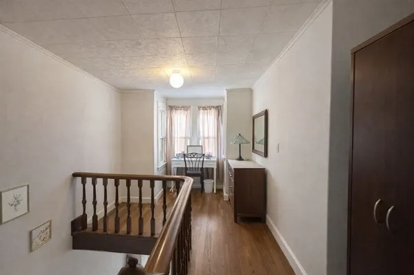 a view of a hallway with wooden floor and windows