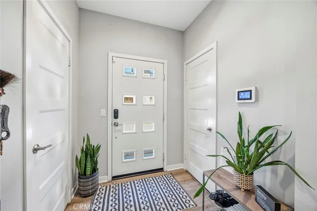 a view of a hallway with wooden floor and a potted plant