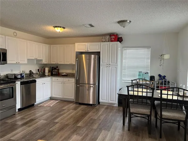 a kitchen with a refrigerator a table and chairs