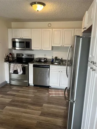 a kitchen with stainless steel appliances granite countertop a refrigerator stove a sink and a microwave