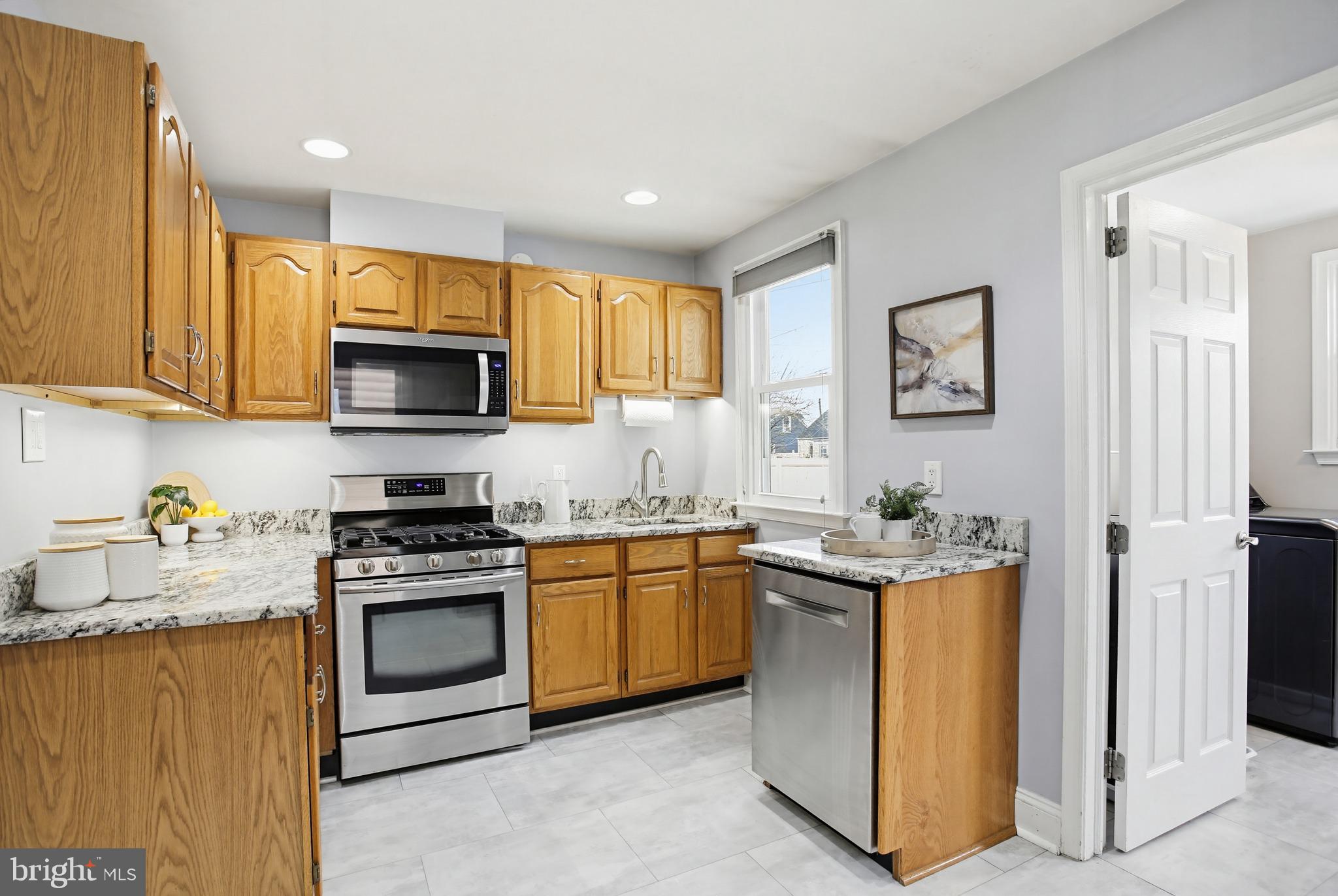 8209 Longpoint Road Baltimore, MD 21222 - Photo 7 of 37 a kitchen with stainless steel appliances granite countertop a stove top oven a sink a refrigerator and a microwave