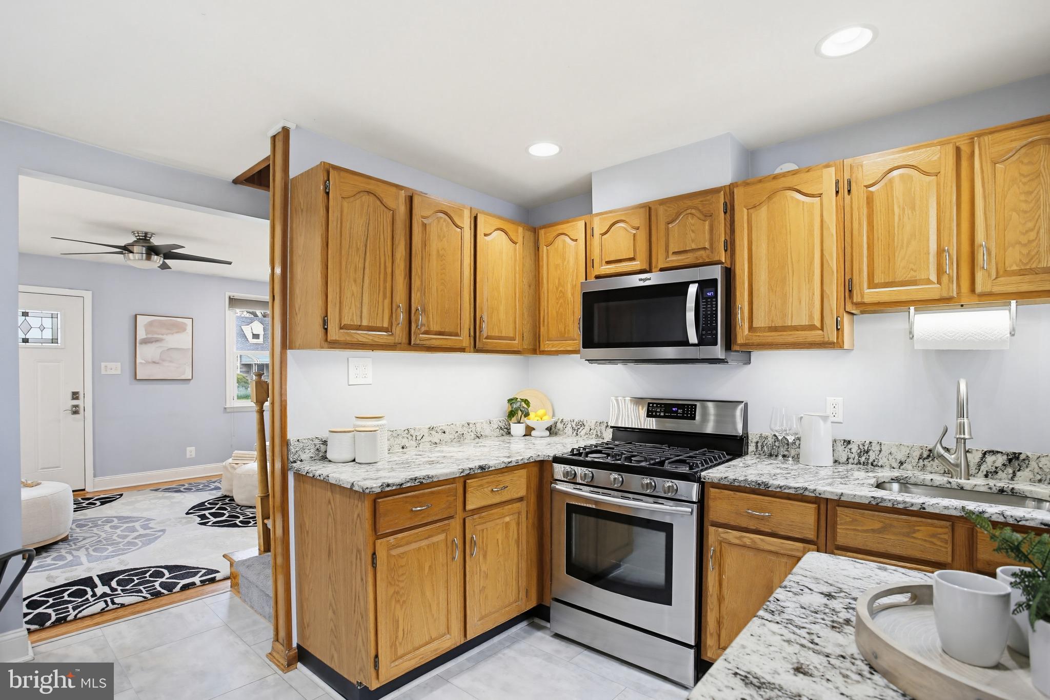 8209 Longpoint Road Baltimore, MD 21222 - Photo 9 of 37 a kitchen with stainless steel appliances granite countertop a stove a sink and a microwave