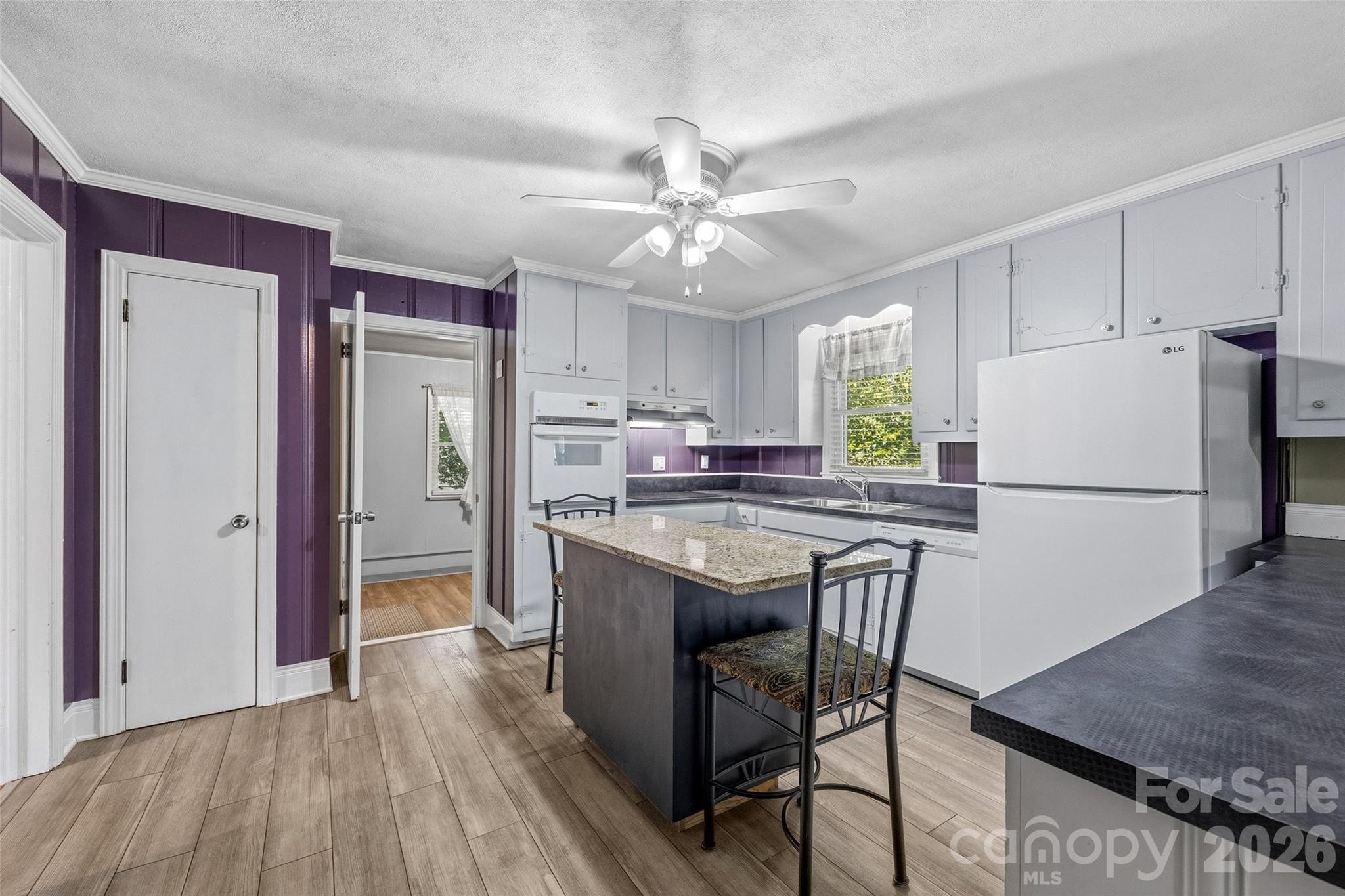 407 Pine Street Fort Mill, SC 29715 - Photo 14 of 45 a kitchen with kitchen island a sink a stove a refrigerator cabinets and wooden floor