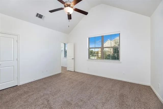 an empty room with windows and fan