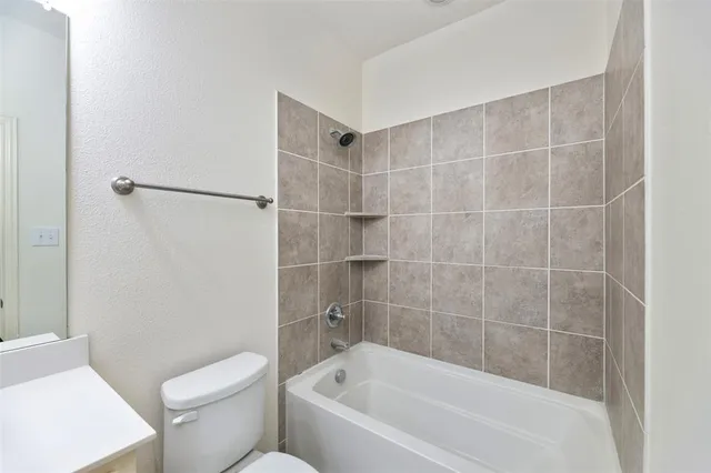 a white bath tub sitting next to a white toilet and a sink