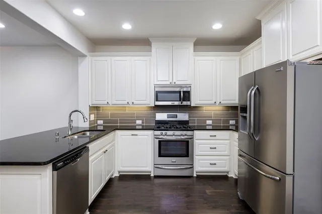 a kitchen with stainless steel appliances a refrigerator stove and sink