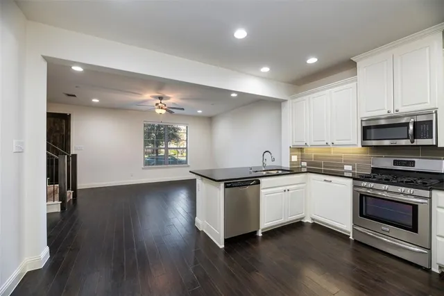 a kitchen with granite countertop a stove cabinets and wooden floor