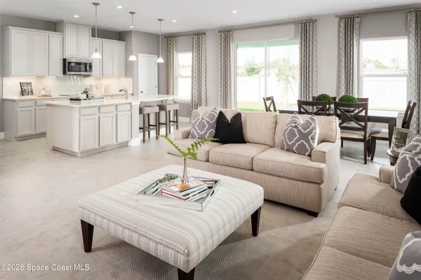 a living room with furniture kitchen and a large window