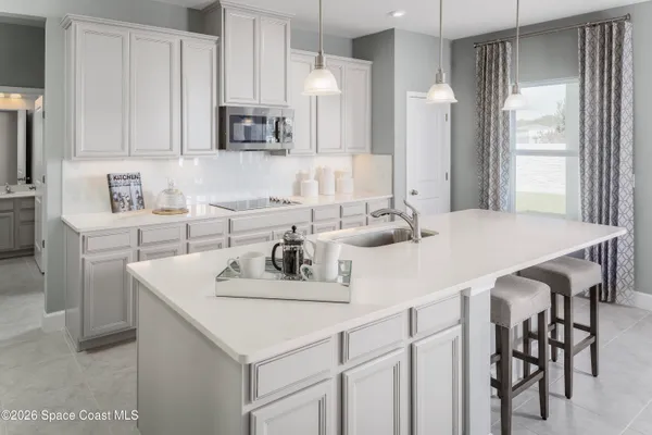 a kitchen with kitchen island a sink table and chairs