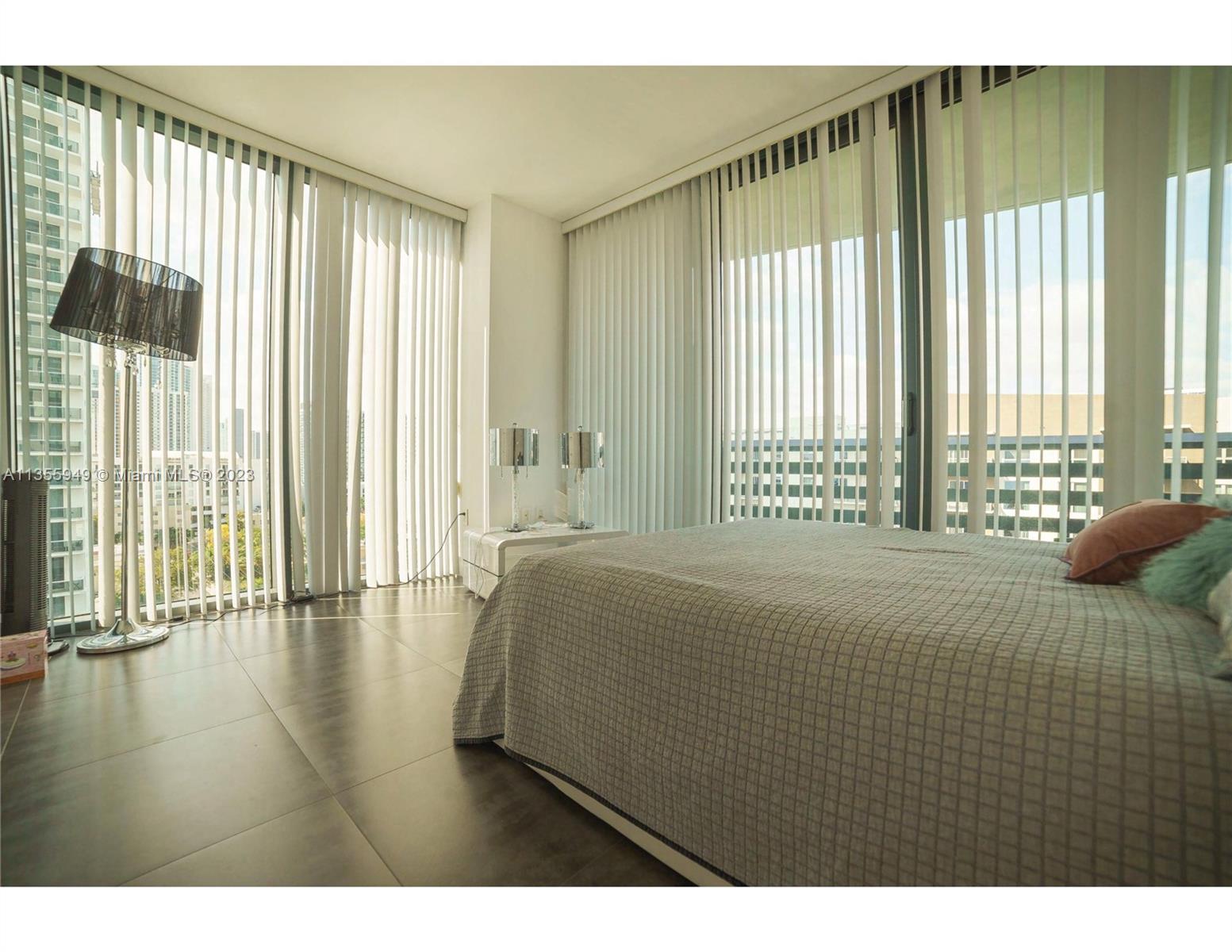 460 Northeast 28th Street, Unit 808 Miami, FL 33137 - Photo 11 of 20 a bedroom with a bed and wooden floor