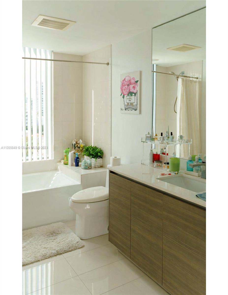 460 Northeast 28th Street, Unit 808 Miami, FL 33137 - Photo 12 of 20 a bathroom with a bath tub a sink and a large mirror