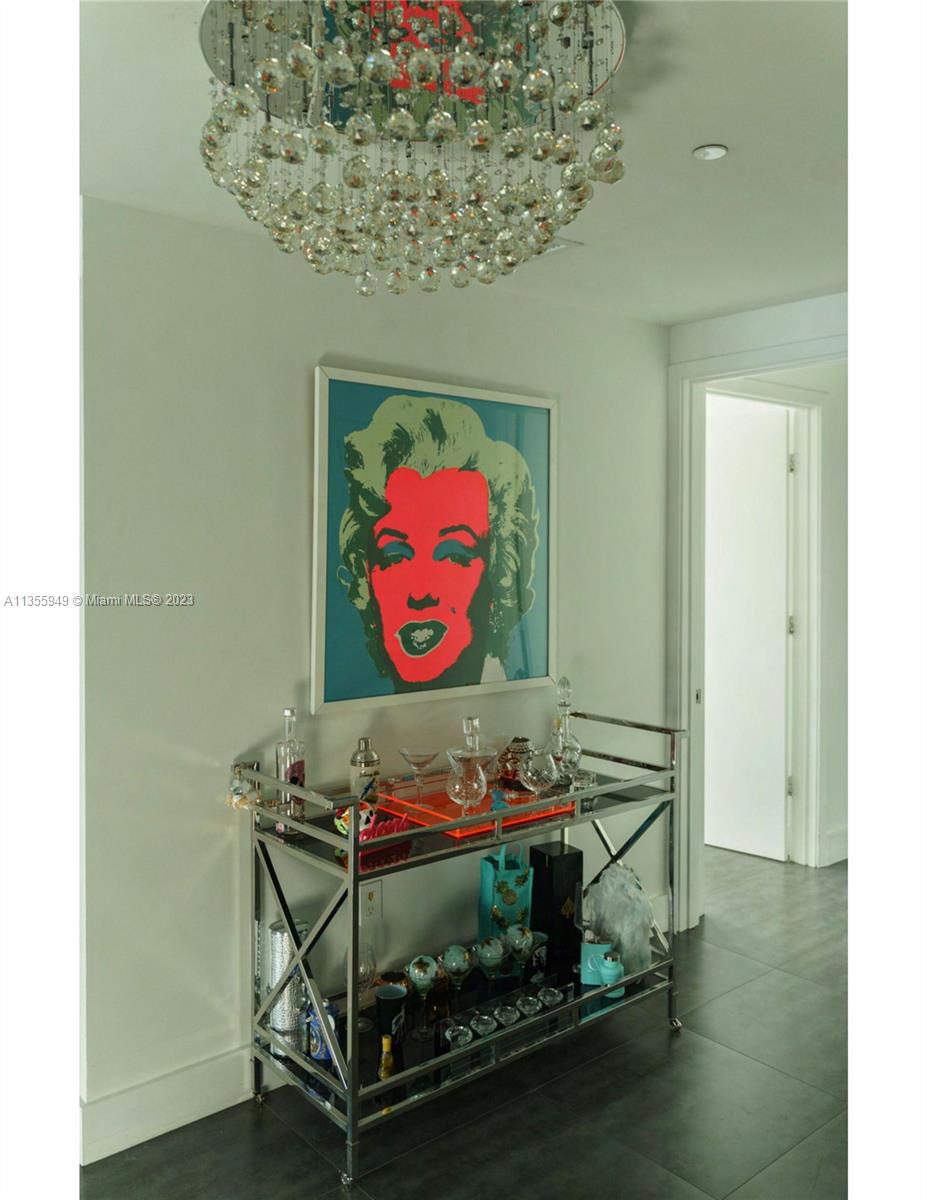 460 Northeast 28th Street, Unit 808 Miami, FL 33137 - Photo 18 of 20 a room with wooden floor and paintings on th wall
