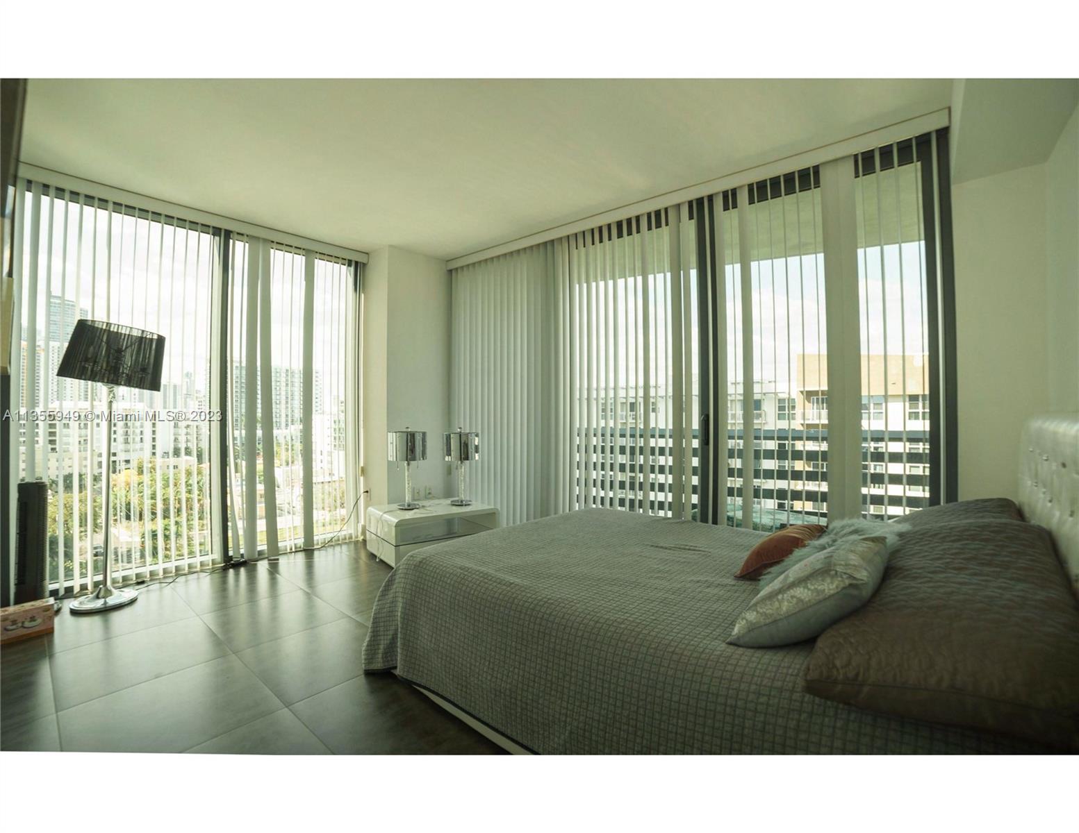 460 Northeast 28th Street, Unit 808 Miami, FL 33137 - Photo 10 of 20 a bedroom with a bed and a large window
