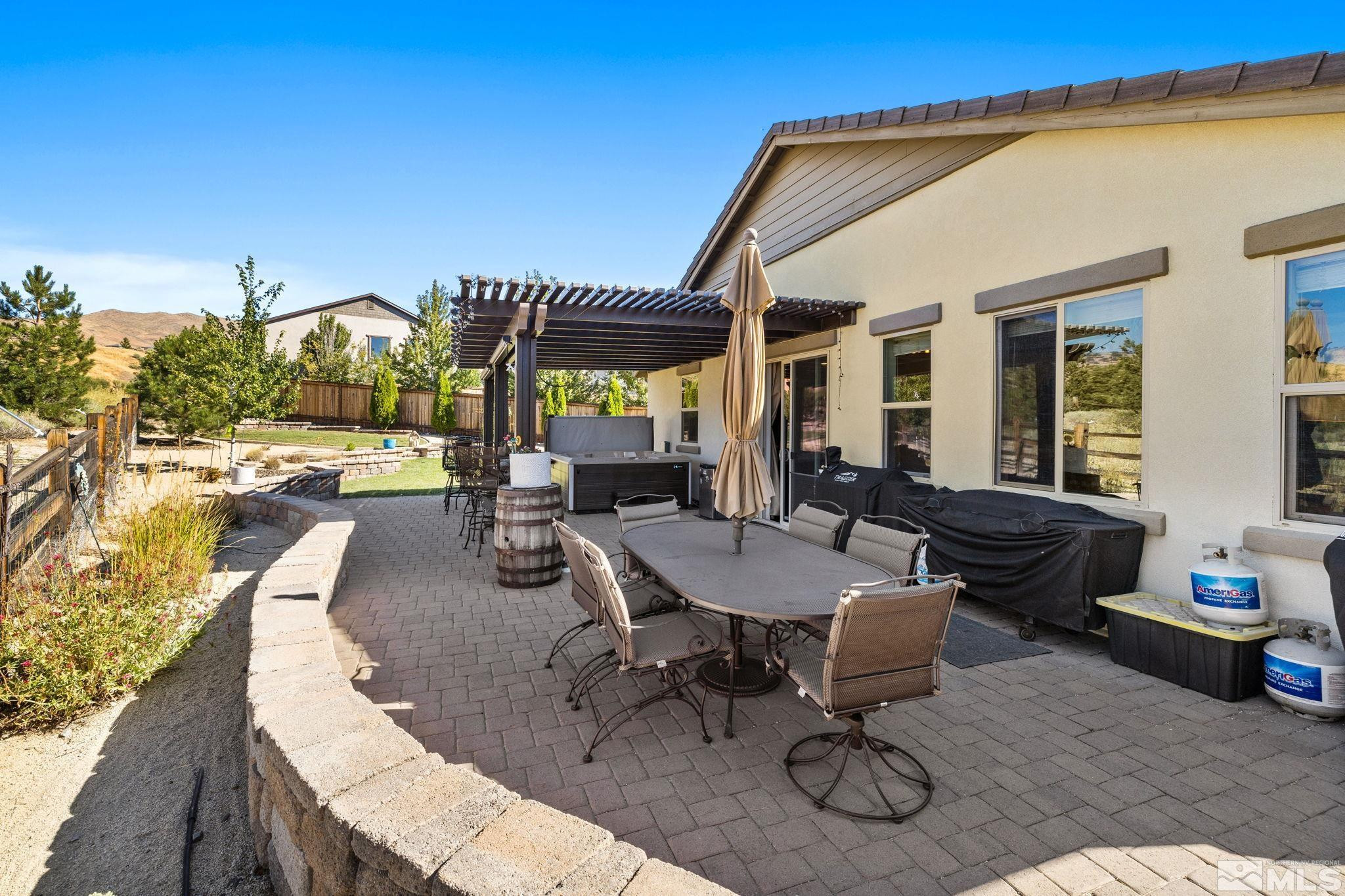 1735 Samantha Crest Trail Reno, NV 89523 - Photo 31 of 32 a view of a patio with table and chairs with wooden floor and fence