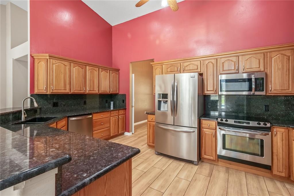 1969 Northwest 111th Loop Ocala, FL 34475 - Photo 20 of 48 a kitchen with stainless steel appliances granite countertop a refrigerator a stove top oven and sink