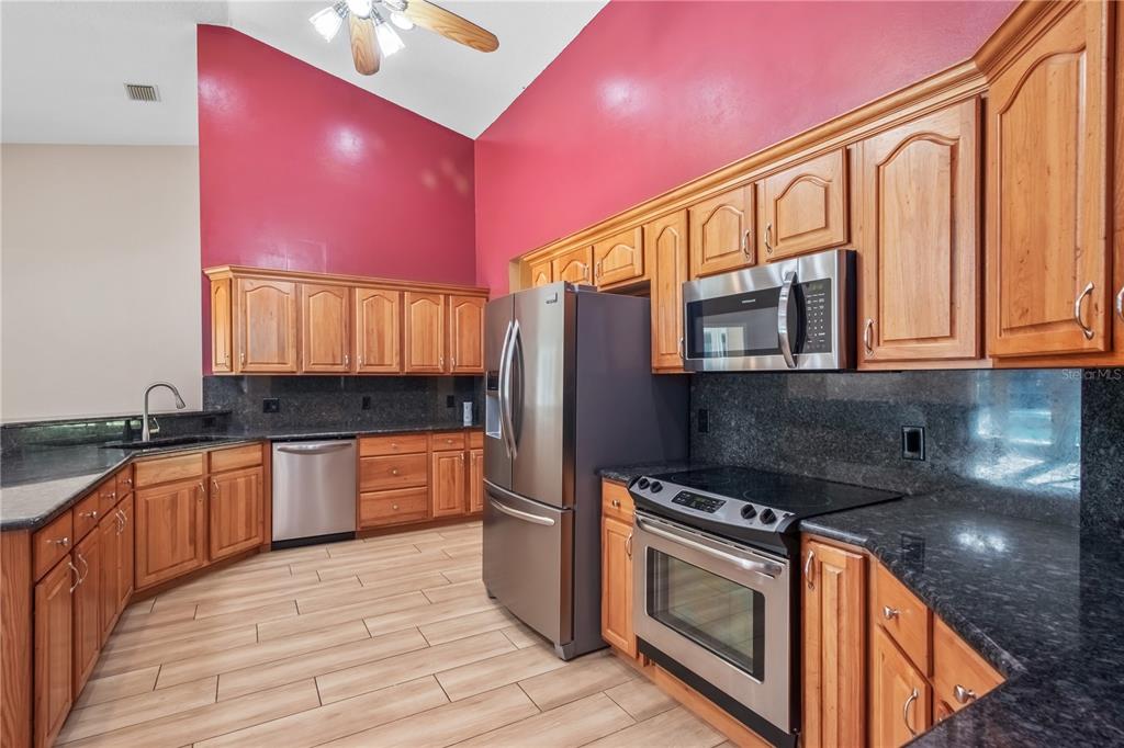 1969 Northwest 111th Loop Ocala, FL 34475 - Photo 22 of 48 a kitchen with stainless steel appliances granite countertop a stove a sink and a microwave