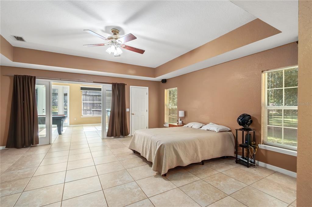 1969 Northwest 111th Loop Ocala, FL 34475 - Photo 37 of 48 a bedroom with a large bed and a chandelier